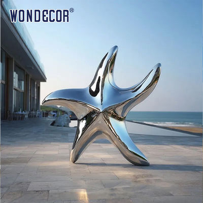 Large stainless steel star shaped outdoor sculpture in the park